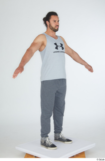 Simeon A poses dressed grey joggers grey sneakers grey tank…